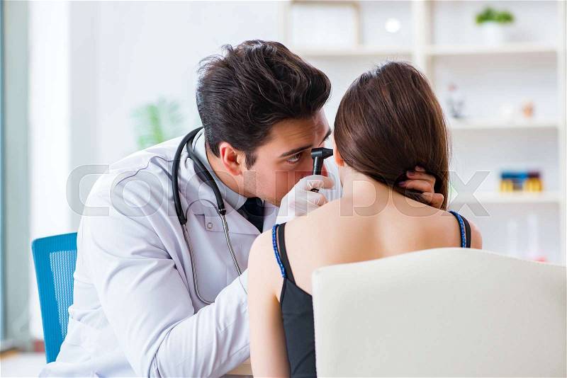 Doctor checking patients ear during medical examination, stock photo