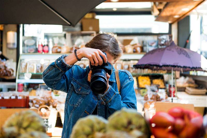 Woman with obscured face by camera taking picture in shop , stock photo