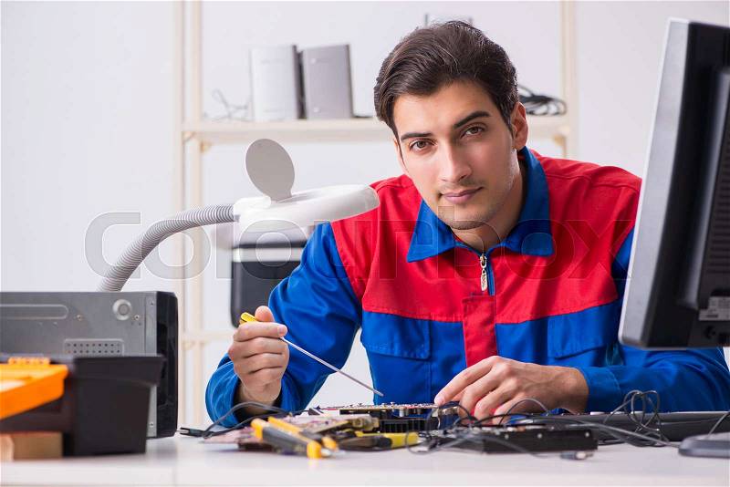 Professional repairman repairing computer in workshop, stock photo