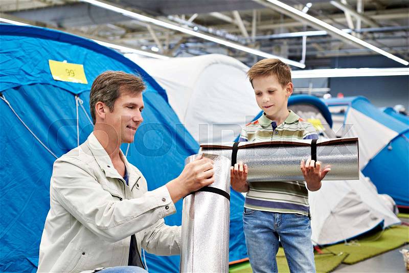 Dad with his son with a tourist camp mat in a sports shop, stock photo