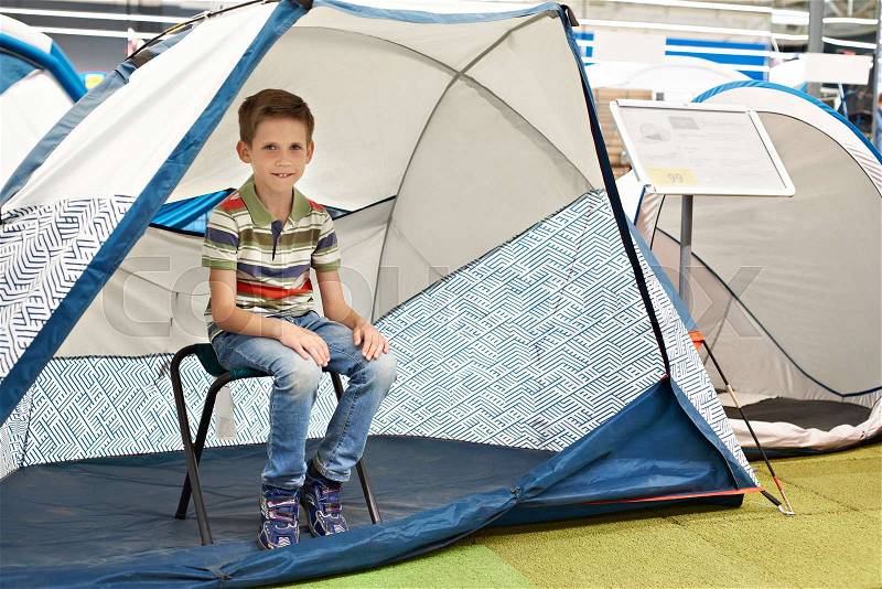 Boy in a tourist tent in a sports shop, stock photo