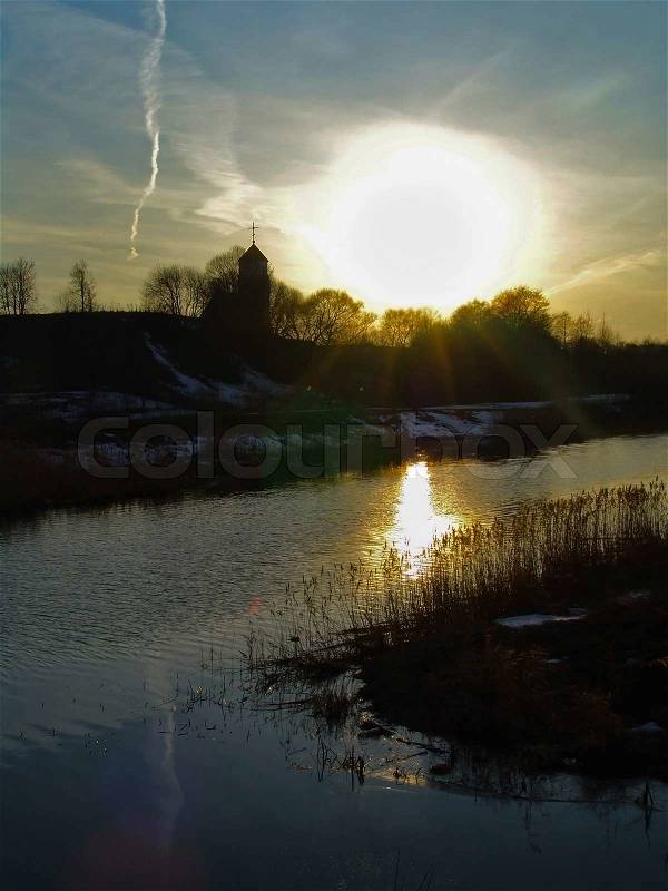 Church on the banks of the river the sun reflected in water, stock photo
