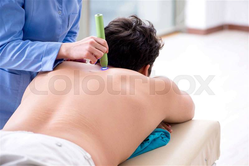 Patient in clinic undergoing laser scar removal, stock photo