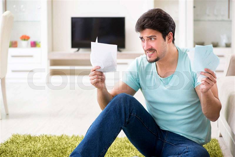Young man struggling with personal finance and bills, stock photo