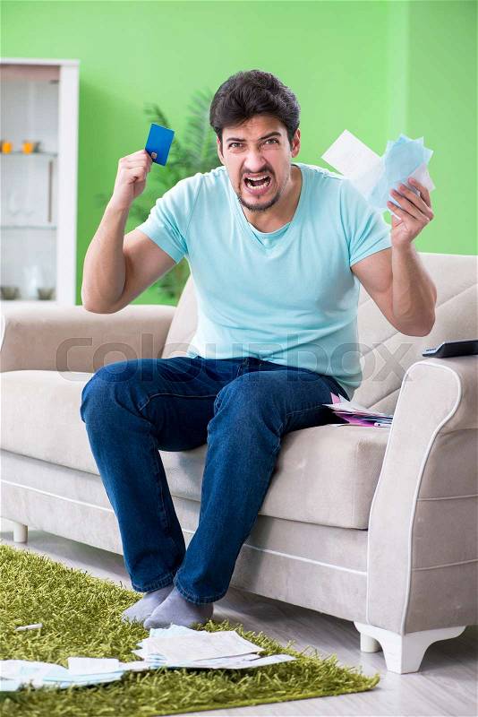 Young man struggling with personal finance and bills, stock photo