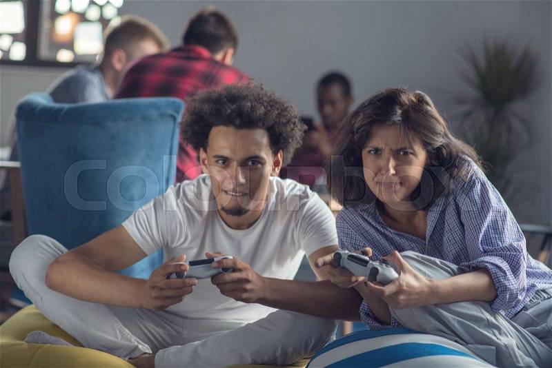Happy couple playing video games at the modern startup office, stock photo