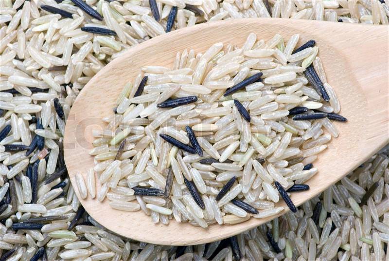 Raw white and black uncultivated rice and wooden spoon close-up, stock photo