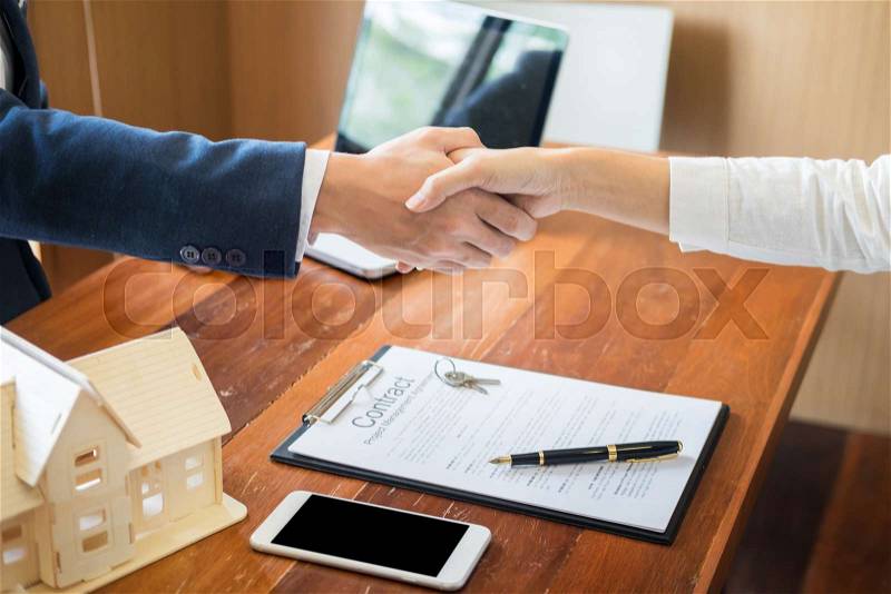 House developers agent or financial advisor and customers shaking hands after signing document making deal as successful agreement, contract with a firm, stock photo