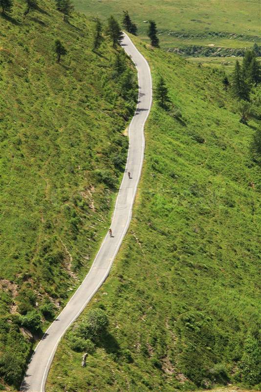 Road running through alpine hills, stock photo