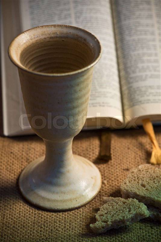 Chalice of wine, open bible and bread, stock photo