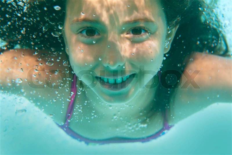 Underwater girl in swimming pool, stock photo