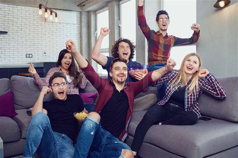 A group of friends are having fun watching TV in the room. A party of friends, stock photo