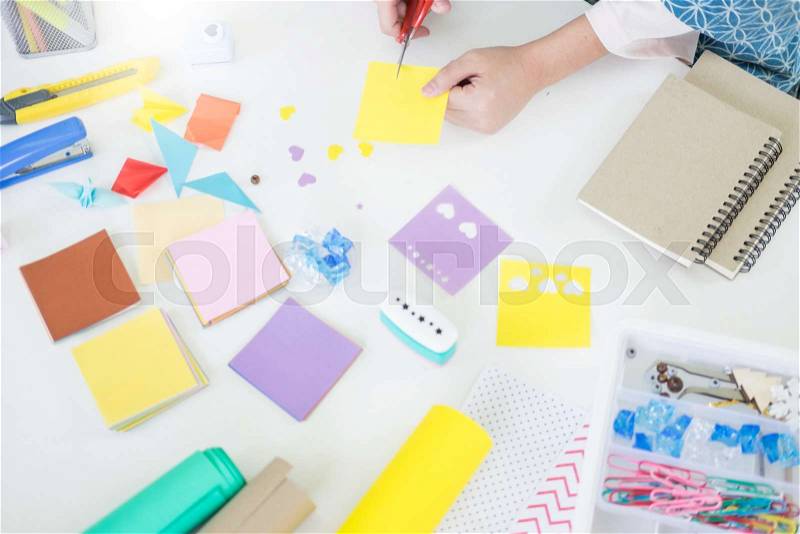 Woman\'s hand cut paper Making a scrap booking or other festive decorations DIY accessories arrangement, stock photo