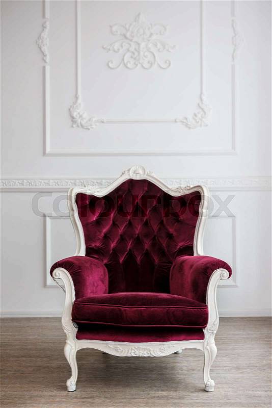 Red velour wood armchair in white room, stock photo