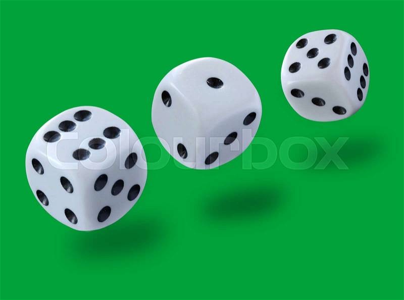 White dices thrown in a craps game, yatsy or any kind of dice game against a green background , stock photo