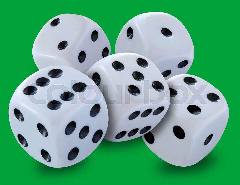 White dice in a pile thrown in a craps game, yatsy or any kind of dice game against a green background, stock photo