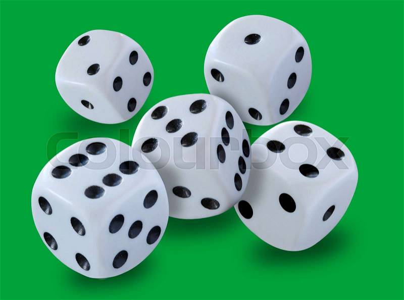 White dices thrown in a craps game, yatsy or any kind of dice game against a green background , stock photo