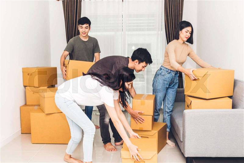 Group of friends holding box and moving into their new home.House moving and real estate concept, stock photo