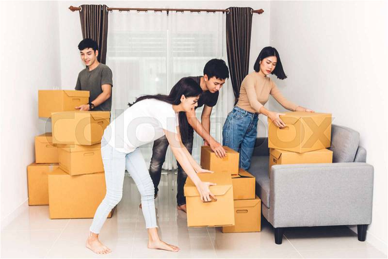 Group of friends holding box and moving into their new home.House moving and real estate concept, stock photo