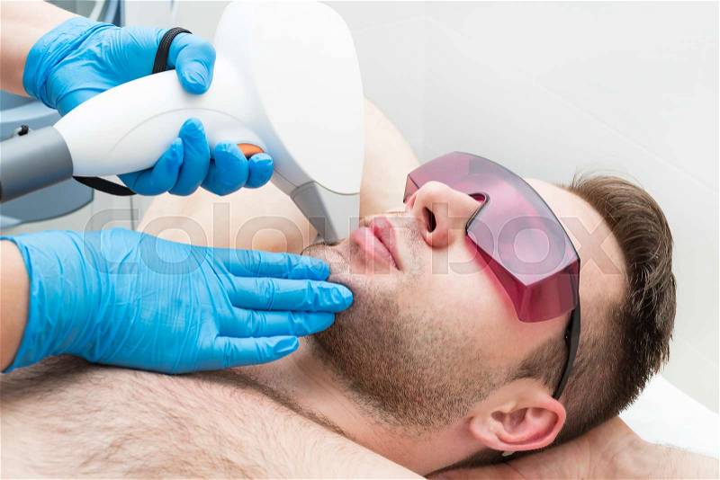 Man on the procedure of laser hair removal in the beauty salon, stock photo