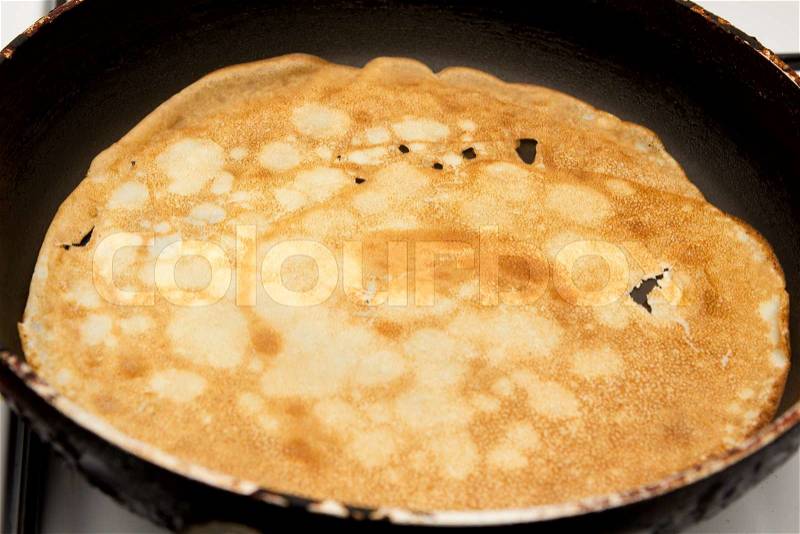 Frying a pancake cooking in a pan, stock photo