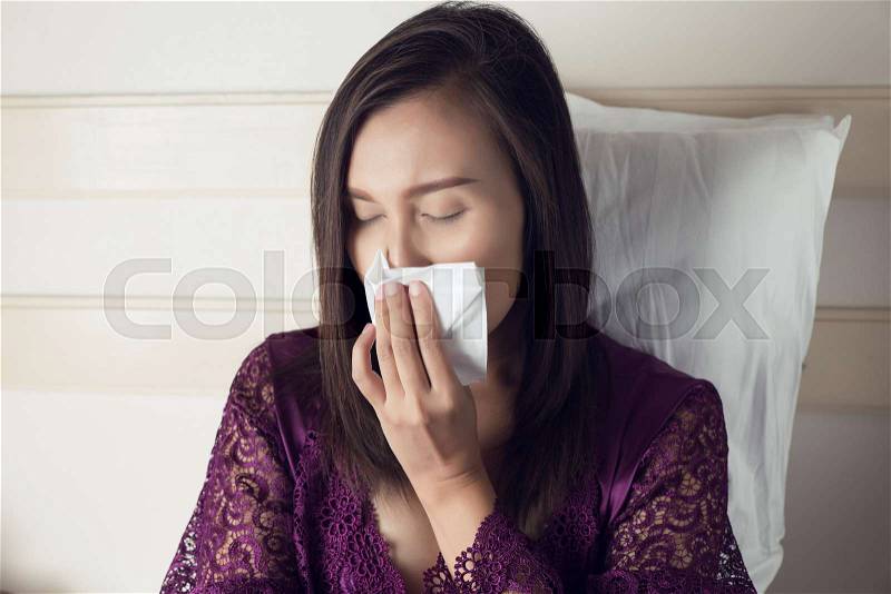 Asian women in satin robes feeling unwell and sinus against gray background. Dust allergies. Flu. People caught cold and allergy, stock photo