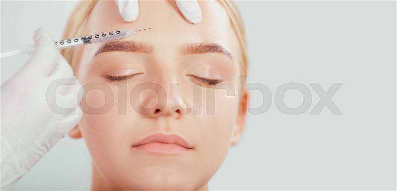 Cosmetic injection to a young woman. Beautician makes the injection of a girl lifting, stock photo