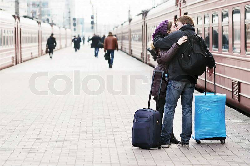 Happy young couple on railway station platform, stock photo
