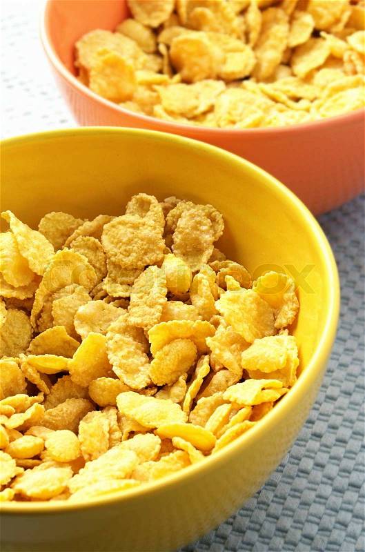 Yellow and orange bowls with corn flakes, stock photo