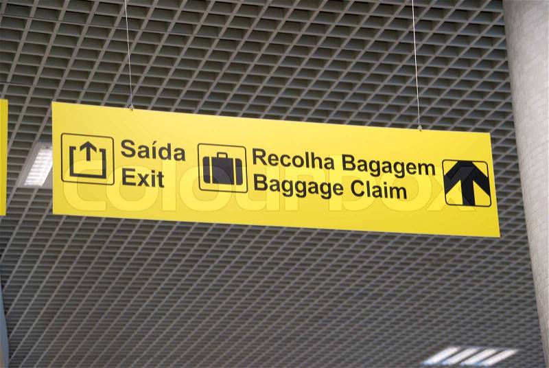 Yellow exit and baggage claim sign at a international airport hanging on a ceiling, stock photo
