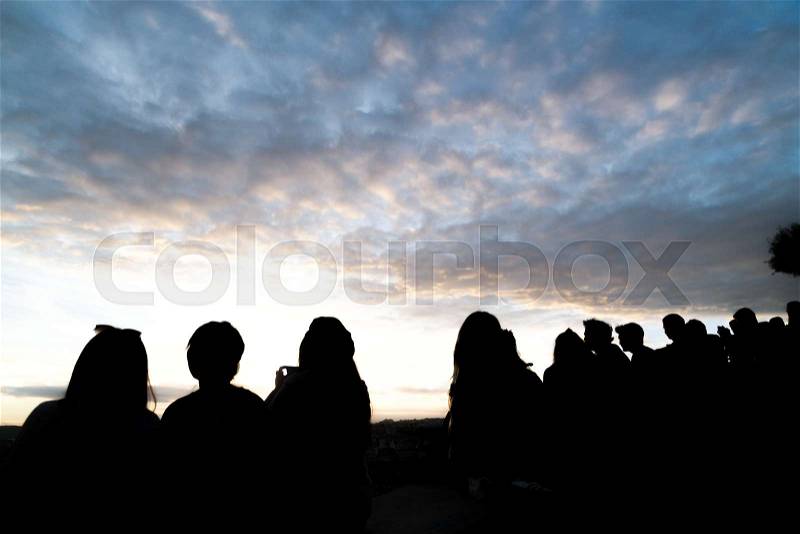 Back view of people silhouettes photographing sunset, stock photo
