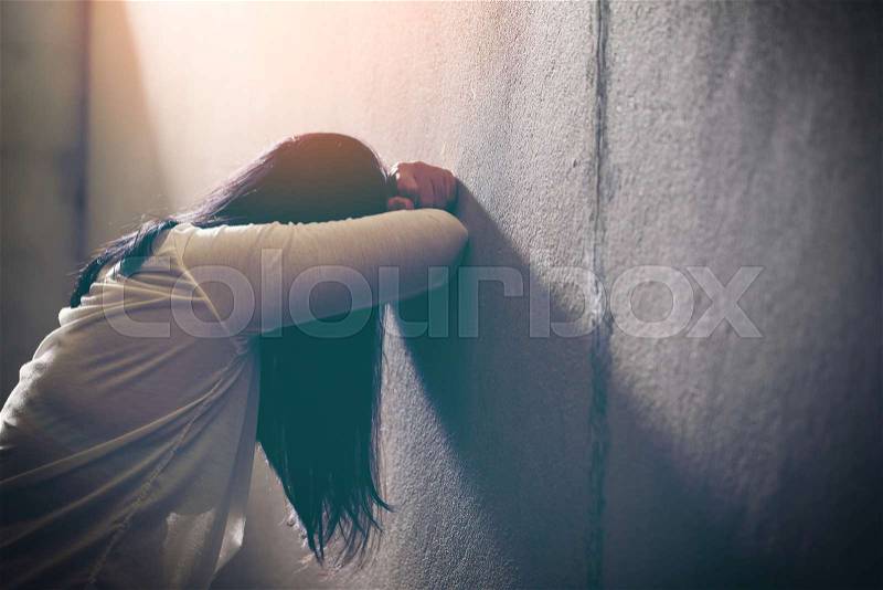 Asian woman sad alone sitting near old wall cement, stop violence against Women, international women\'s day, stock photo