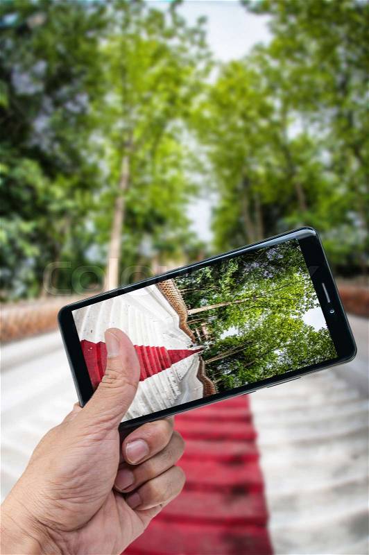 Hand holding smartphone landscape nature background, stock photo