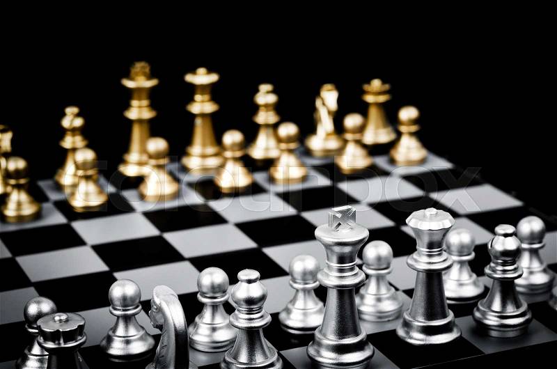 Chess game face with the another silver team on black background (Concept for company strategy, business victory or decision), stock photo