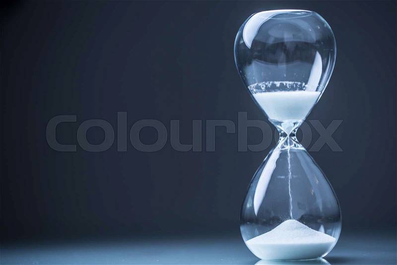 Modern hourglass in running time in studio lights, stock photo