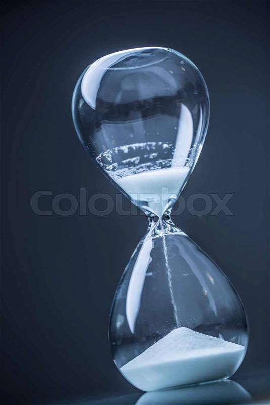 Modern hourglass in running time in studio lights, stock photo