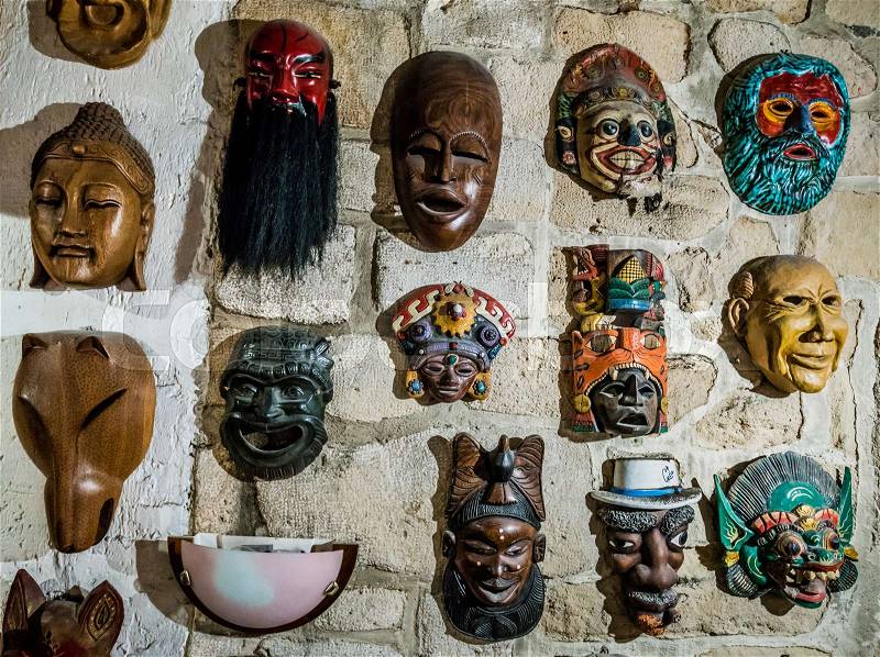 Masks hanging on wall. Collection of masks, stock photo