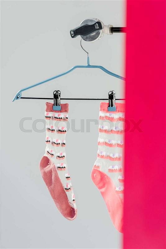 Pair of pink socks with cake pattern on hanger, stock photo