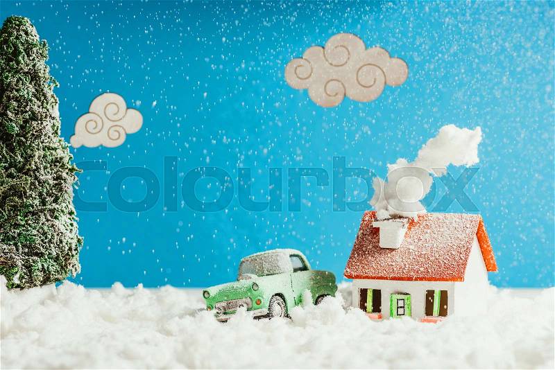 Close-up shot of toy car and house covered with snow, christmas concept, stock photo
