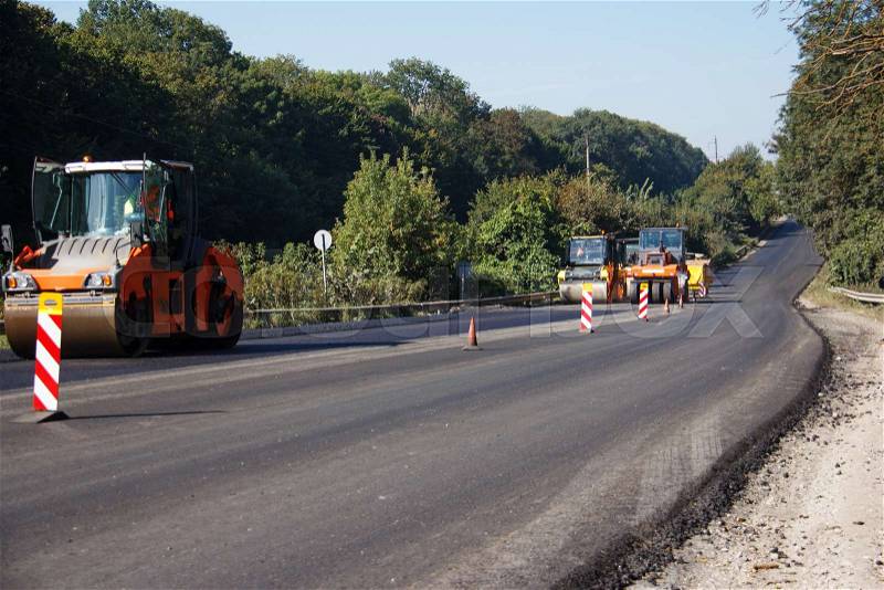 Carrying out repair works: asphalt roller stacking and pressing hot lay of asphalt. Machine repairing road, stock photo