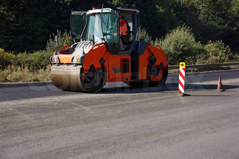 Carrying out repair works: asphalt roller stacking and pressing hot lay of asphalt. Machine repairing road, stock photo