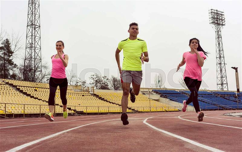 Young caucasian friends doing running practice on ground, stock photo