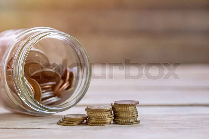 Money in the jar on wooden table with filter effect retro vintage style. Money and business concept, stock photo
