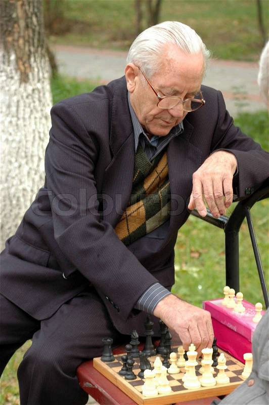 A man playing chess in the park, stock photo
