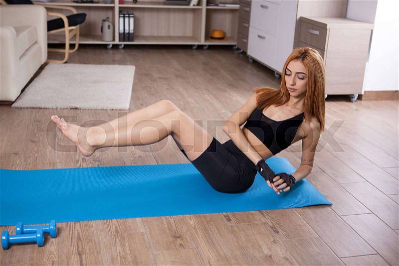 Abs workout with dumbbels by beautiful young woman. No pain no gain, stock photo
