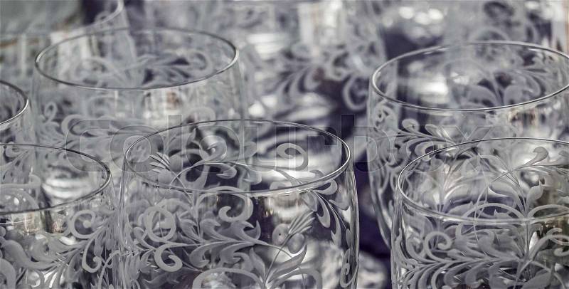 Close-up of cut and cisiliated colourless drinking glasses with abstract patterns, stock photo