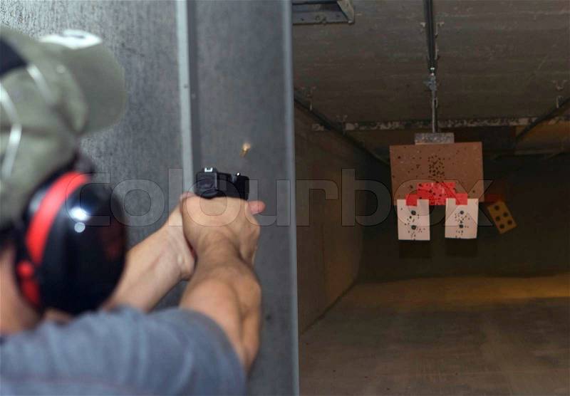 Target practicing with gun In the shooting range, stock photo