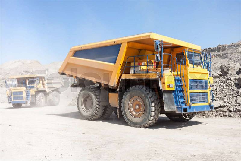Dump trucks moving in a coal mine, stock photo