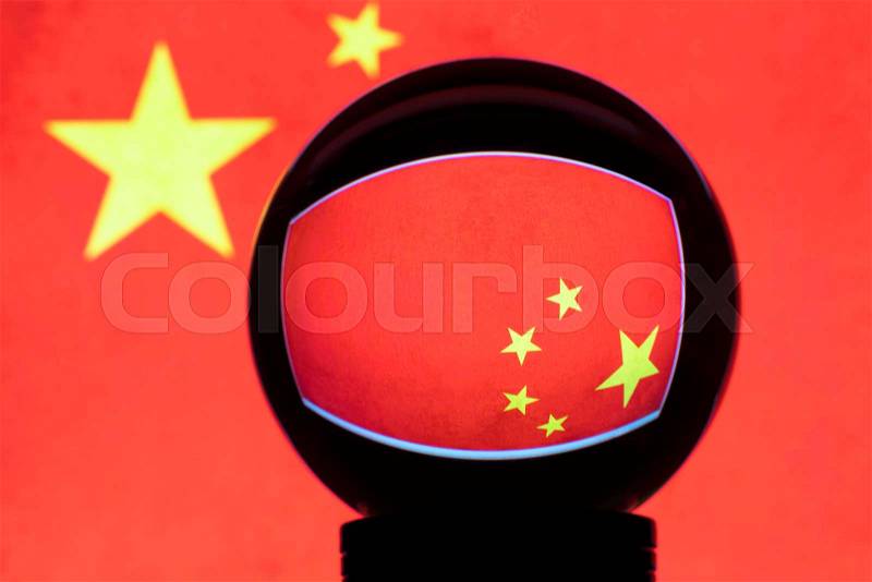 Flag of China in reflection on a crystal ball against a blurred Chinese flag, stock photo