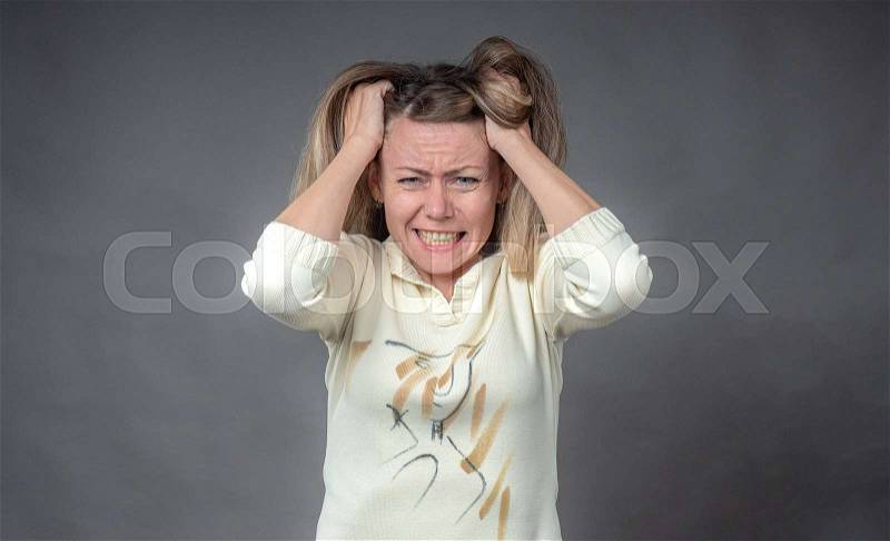 Woman in stress. Girl gritted her teeth in hysterical angry emotion, isolated on gray. Portrait of woman in despair and panic. Negative human emotion on face ..., stock photo